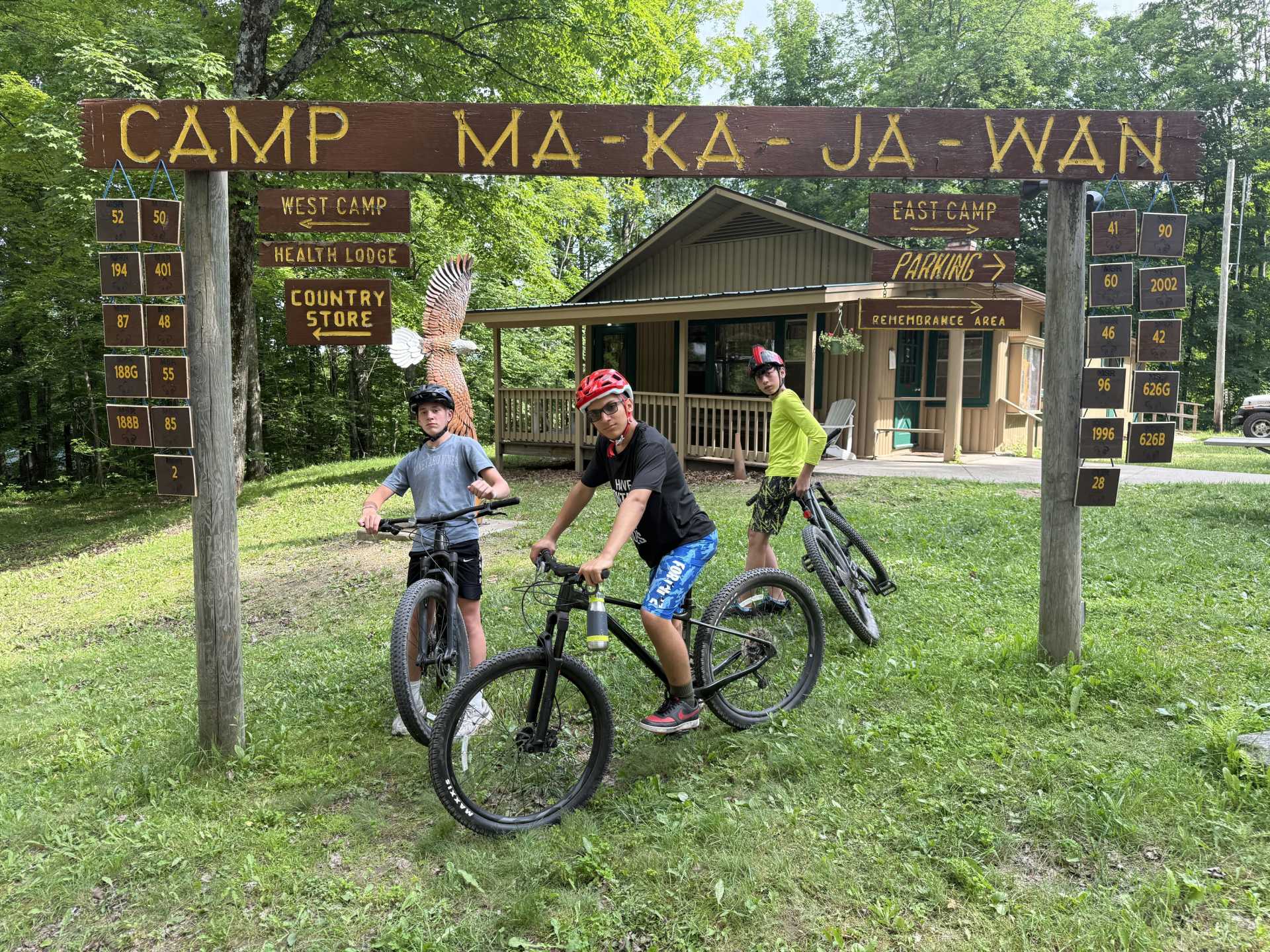 Some scouts begin a trail below a Camp Ma-Ka-Ja-Wan Sign