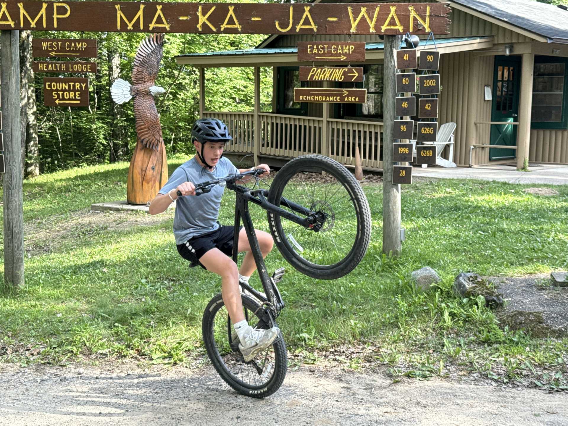 A scout pops a wheelie on their bike