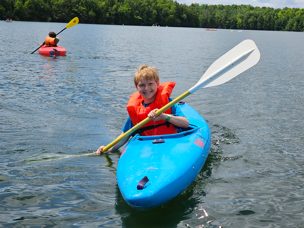 A boy kayaks on the water