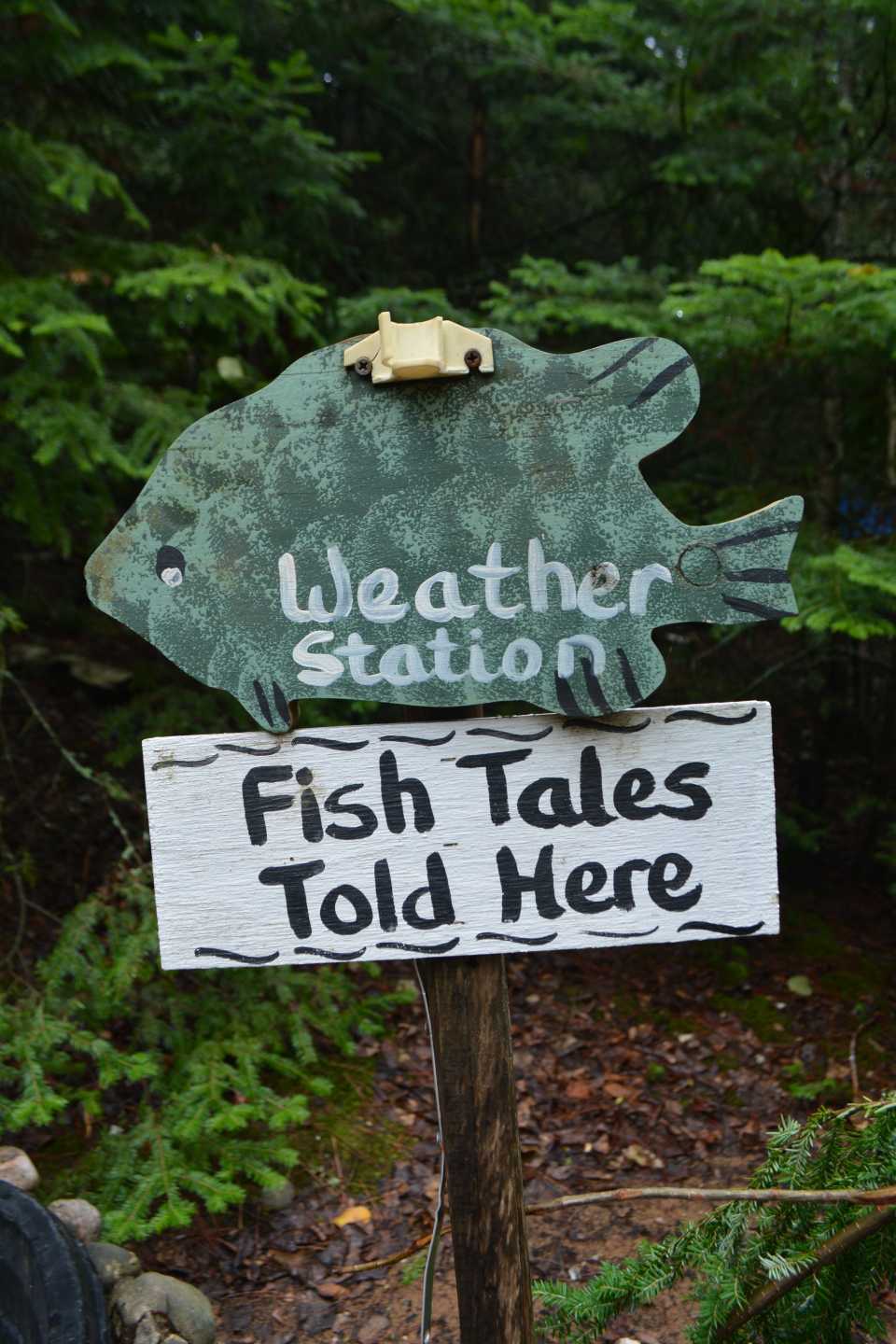 A sign shaped like a fish points towards the weather station, with the label 'fish tales told here'