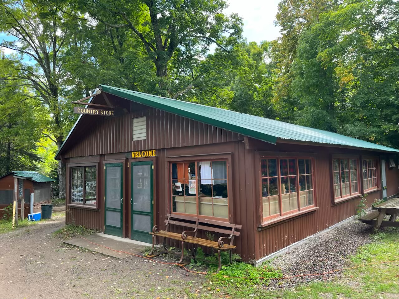 Viewed from outside, the country store is a neat little log-cabin styled building with large windows hosting a number of signs and postings.