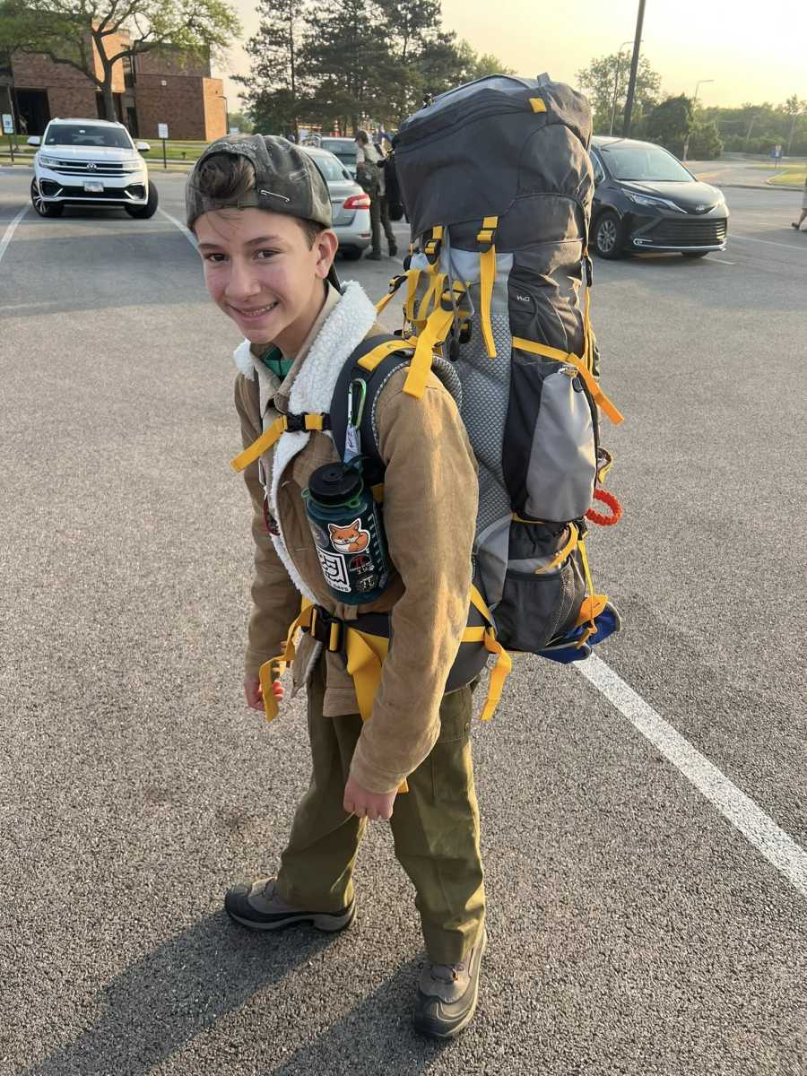 A scout looking very prepared with his camp pack over his shoulder.